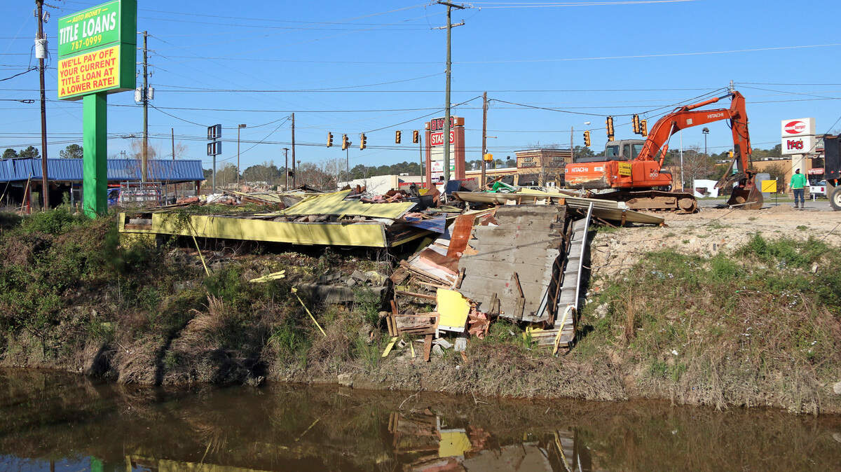 Workers with C.L. Construction demolish the Title Loans building near Devine Street on Monday, March 18, 2019, in Columbia. The structure stood as a reminder of destructive 2015 flooding.