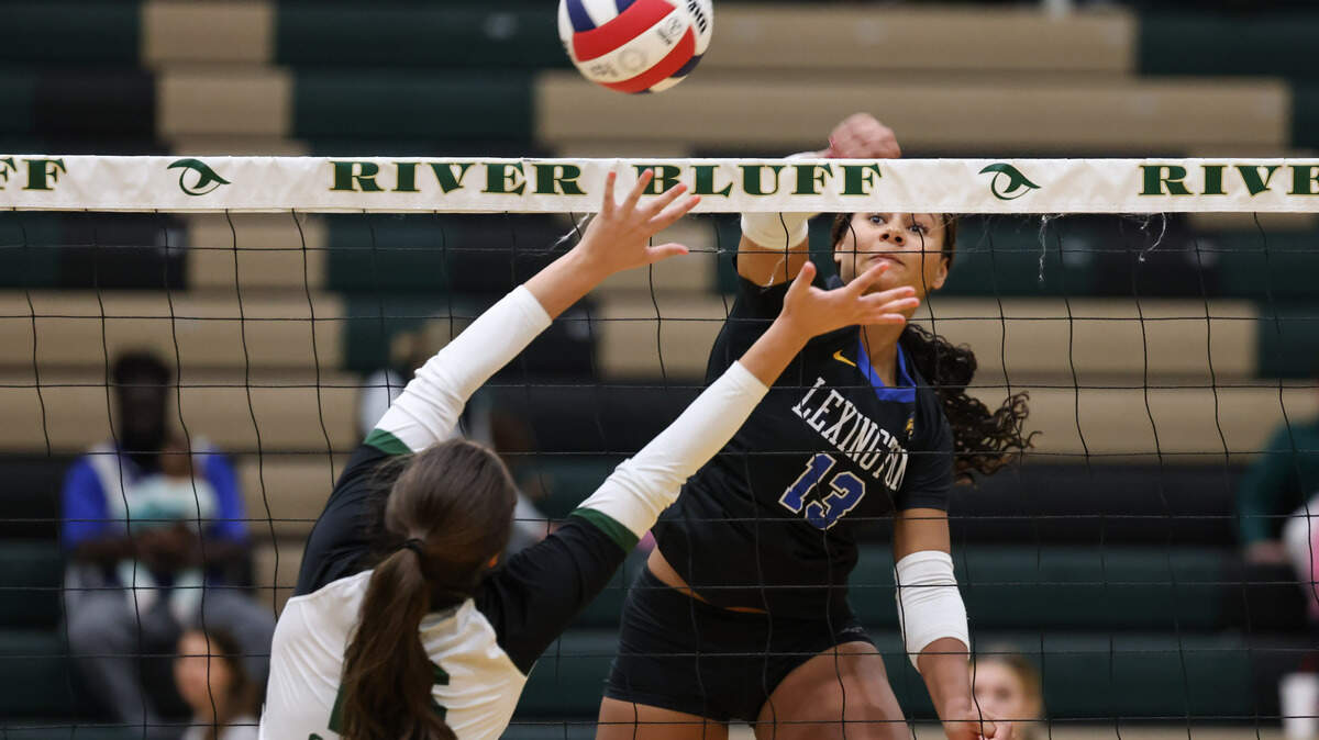 Jasia Brunson (13) of Lexington goes for a kill as Alexis Jodie (16) of River Bluff defends during Lexington’s game against River Bluff at River Bluff in Columbia on Thursday, October 17, 2024.