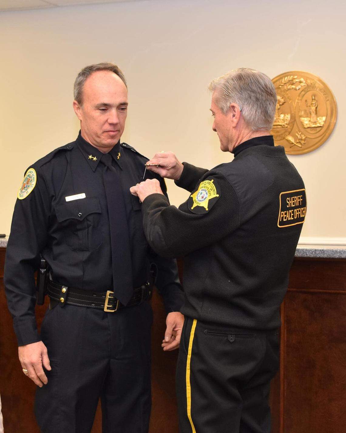 Forest Acres Police Chief Don Robinson, left, in unofficially sworn in by Richland County Sheriff Leon Lott.