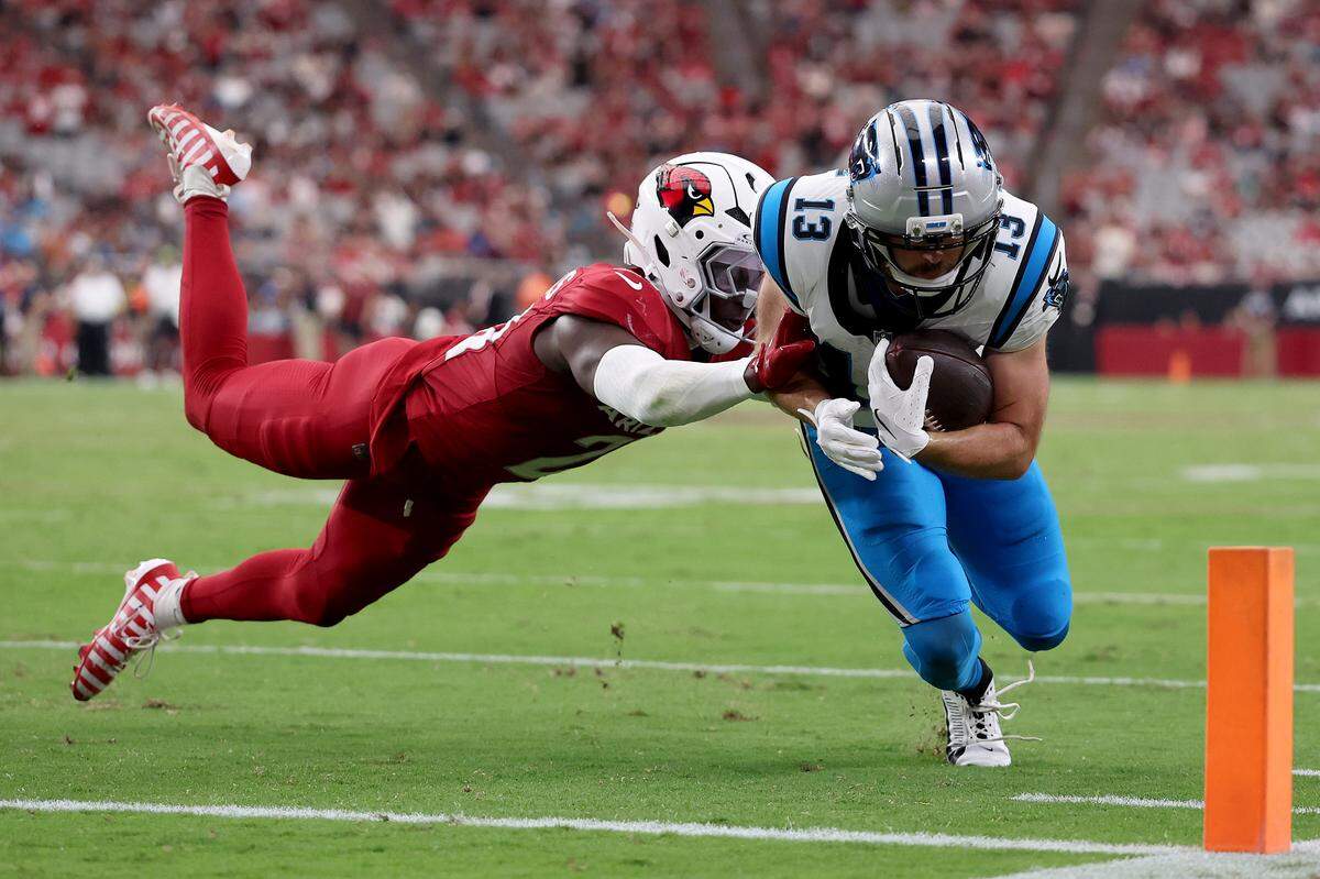 Hunter Renfrow #13 of the Carolina Panthers dives for the pylon as Garrett Williams #21 of the Arizona Cardinals tackles him during the fourth quarter at State Farm Stadium on September 14, 2025 in Glendale, Arizona.