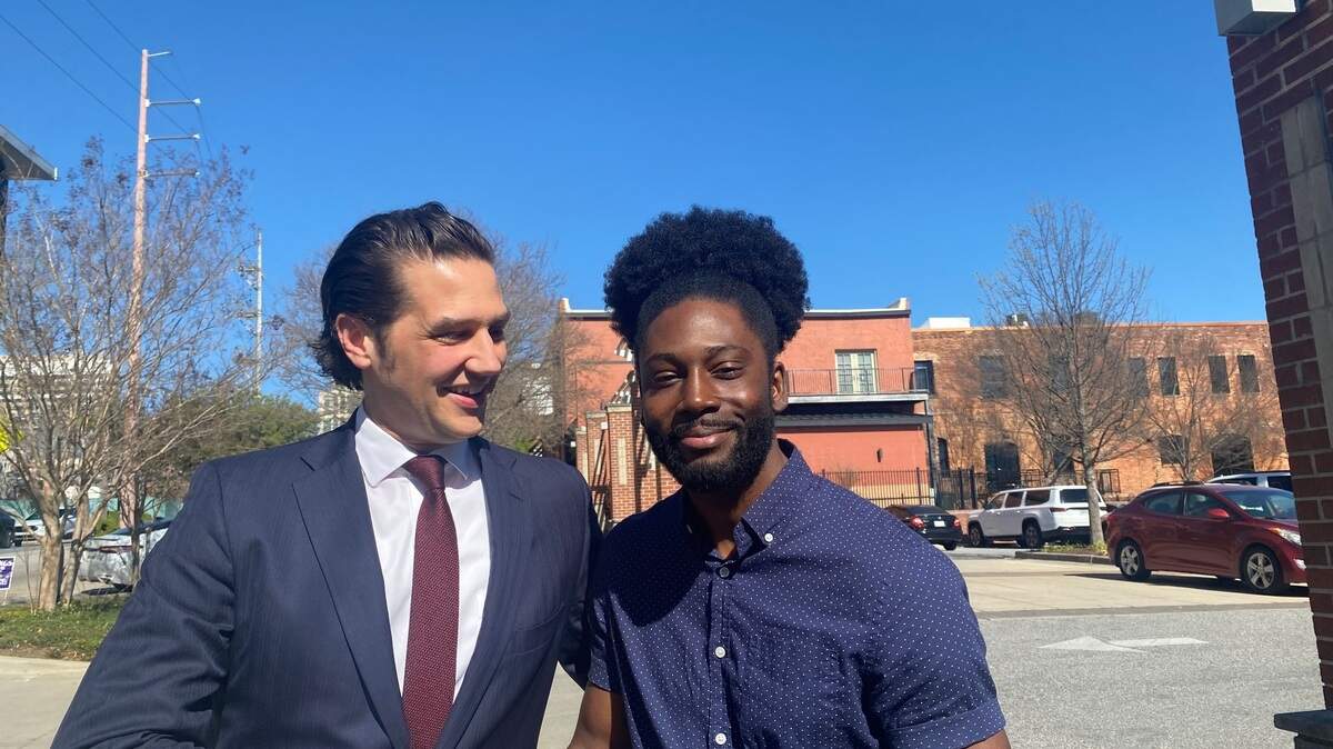 Bryan Wilson (right), falsely indicted on gun and drug charges, shakes hands with his lawyer, Chris Kenney, who got him a hefty settlement from the government.