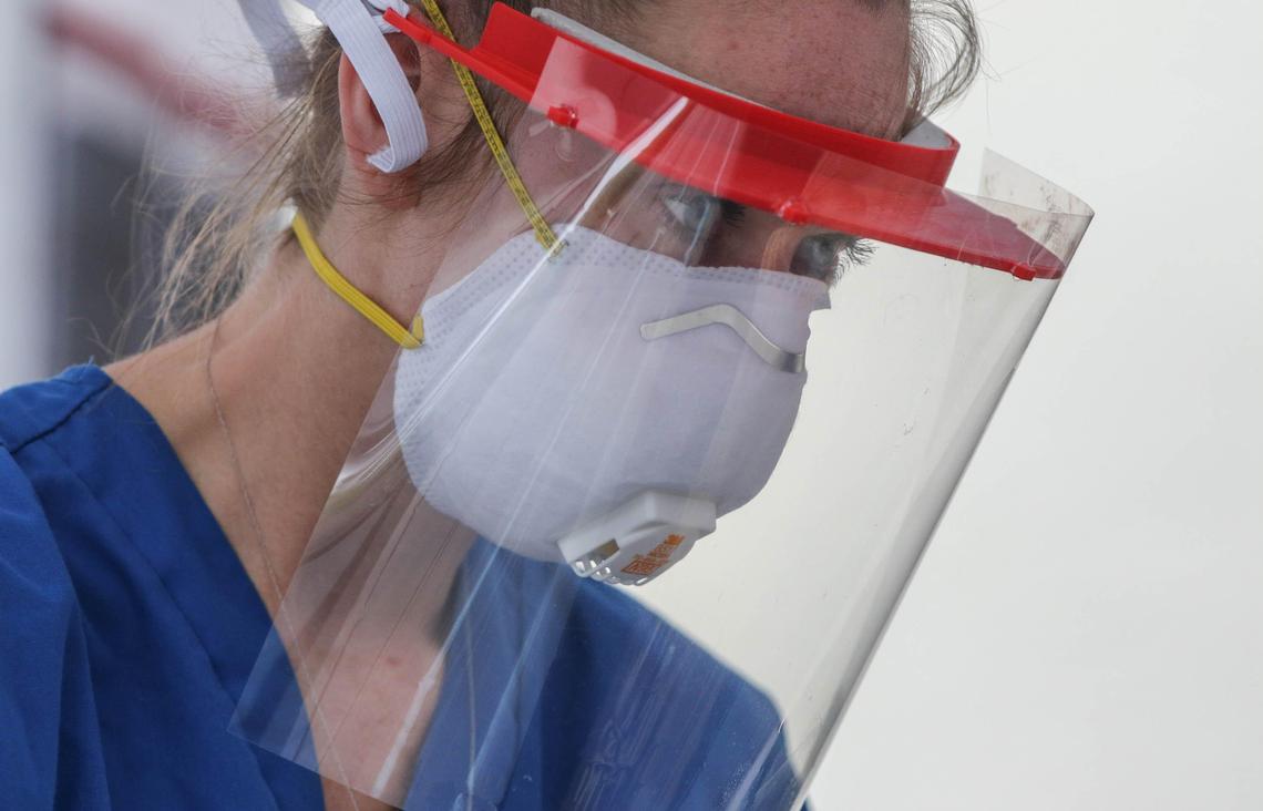 Lindsey Greer, a lead medical technician at Veritas Health Group in Lexington, processes a patient to be tested for the coronavirus at a tent outside the urgent care clinic. They test about 20-30 patients a day for the coronavirus. 4/8/20