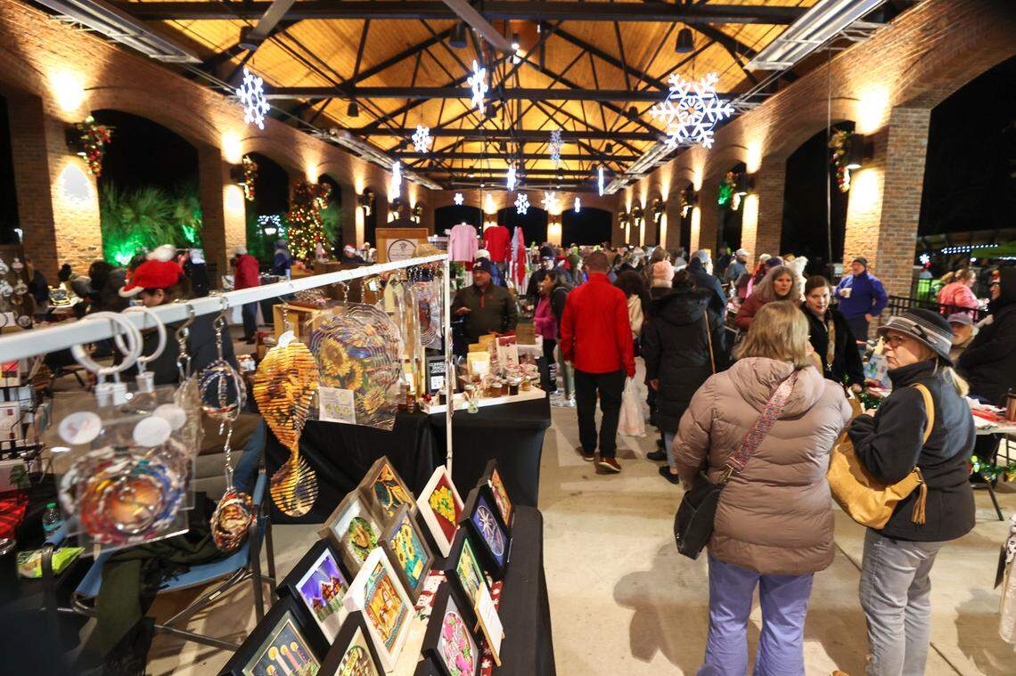 People stroll the market at Lexington’s Icehouse Amphitheater. The crafts market was set up for the Christmas Carolighting Ceremony at the Icehouse Amphitheater on Friday Dec. 6, 2024.