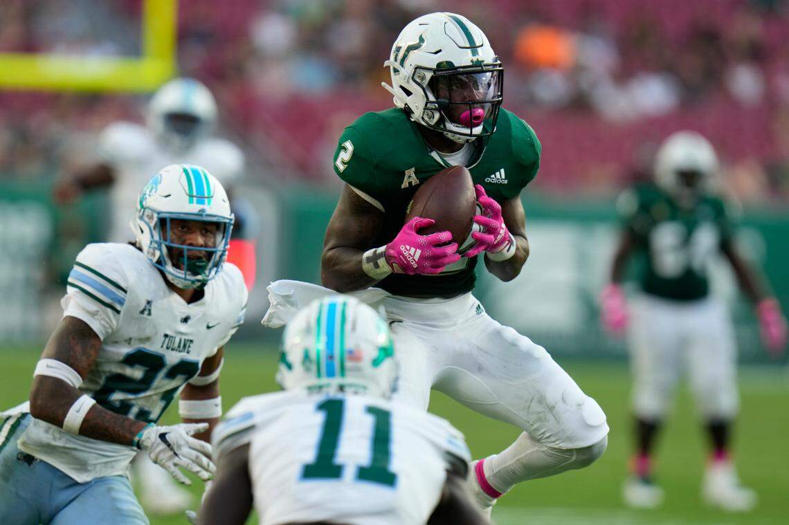 South Florida running back Michel Dukes (2) makes a catch in front of Tulane safety Lummie Young IV (23) and defensive back Jarius Monroe during the second half of an NCAA college football game Saturday, Oct. 15, 2022, in Tampa, Fla. (AP Photo/Chris O’Meara)