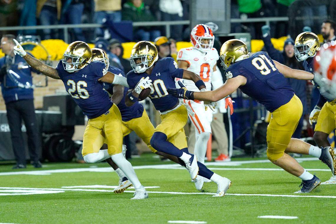 Notre Dame cornerback Benjamin Morrison (20) begins to celebrate with teammates Xavier Watts (26) and Gabriel Rubio after Morrison’s interception of a pass by Clemson quarterback Cade Klubnik during the second half of an NCAA college football game Saturday, Nov. 5, 2022, in South Bend, Ind. Notre Dame won 35-14. (AP Photo/Charles Rex Arbogast)