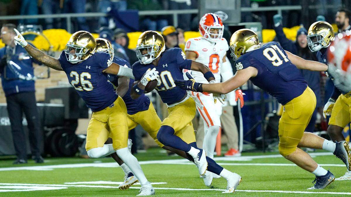 Notre Dame cornerback Benjamin Morrison (20) begins to celebrate with teammates Xavier Watts (26) and Gabriel Rubio after Morrison’s interception of a pass by Clemson quarterback Cade Klubnik during the second half of an NCAA college football game Saturday, Nov. 5, 2022, in South Bend, Ind. Notre Dame won 35-14. (AP Photo/Charles Rex Arbogast)