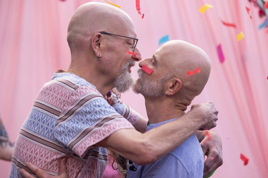 William Bonney and James Carpenter kiss as confetti flies through the air during their wedding at Y’all-Mart, a quarterly art fair series, at Art Bar in Columbia, South Carolina on Sunday, February 9, 2025. Bonney and Carpenter say they are looking forward to not having to carry medical power of attorney paperwork to the hospital and other legal protections married couples have.