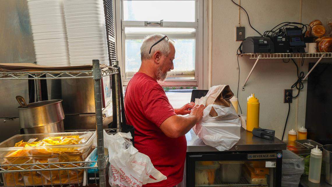 Kipp Shives prepares an order for a food delivery service at his Granby Burger kitchen inside Lucky’s in Five Points on Thursday, August 14, 2025.