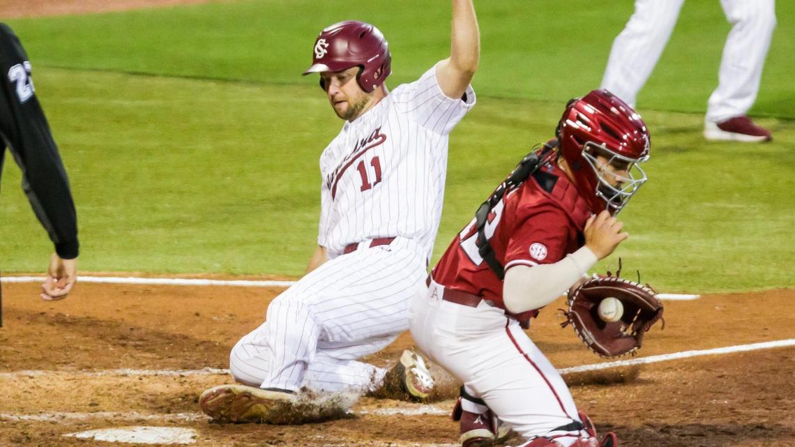 South Carolina Gamecocks outfielder Andrew Eyster (11) slides safely home for a run as Arkansas Razorbacks catcher Casey Opitz (12) takes the late throw during the fourth inning.