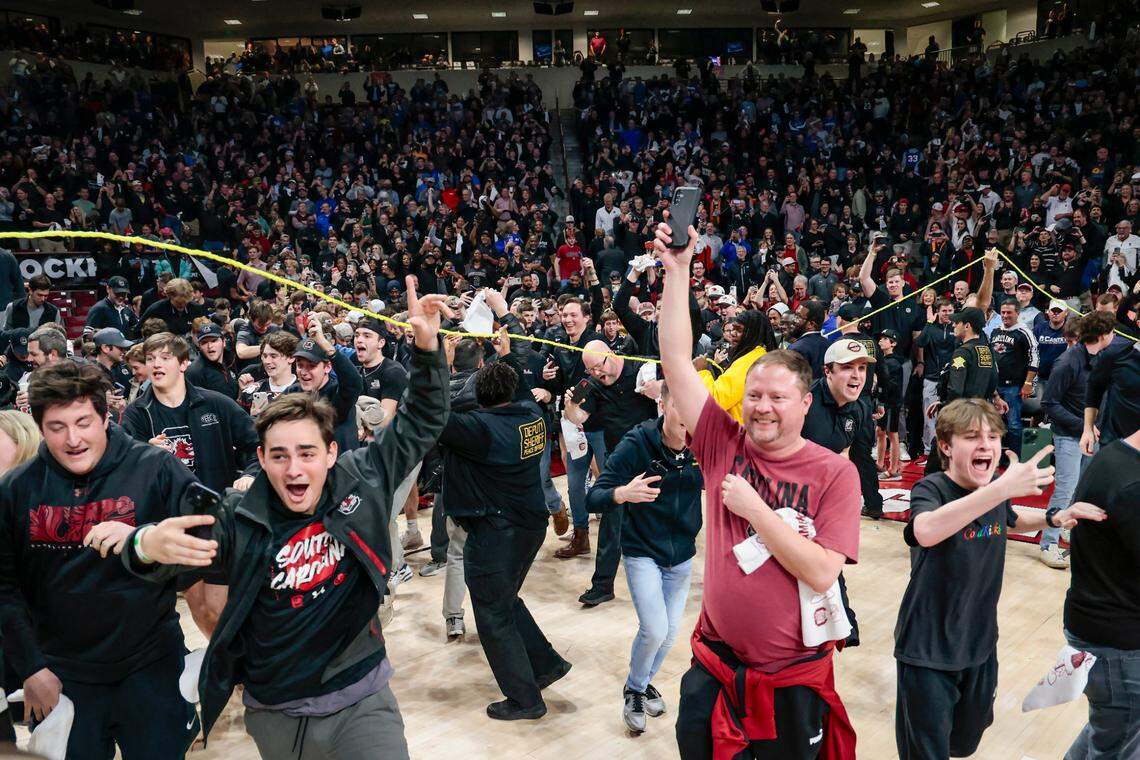Fans storm the court Tuesday at Colonial Life Arena after South Carolina’s upset win over Kentucky.