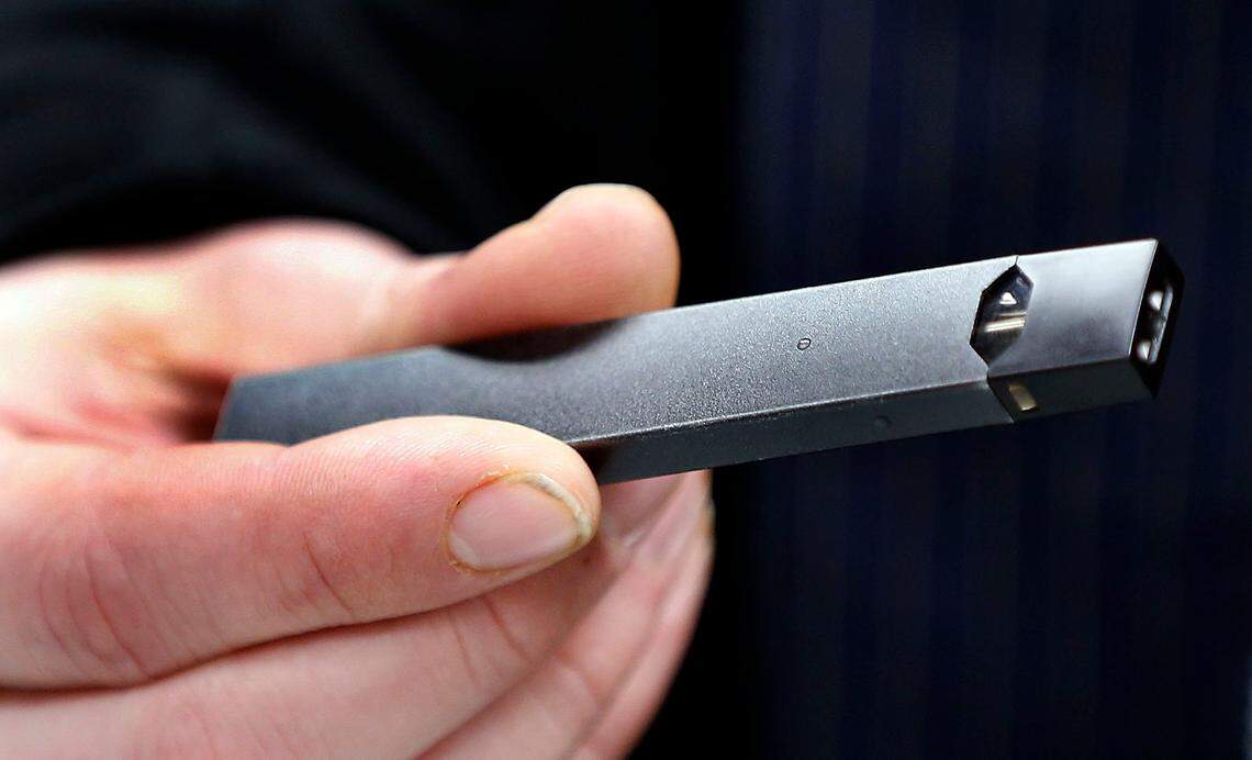 File photo: Nick Gregory, a 26-year-old manager, holds a JUUL device.