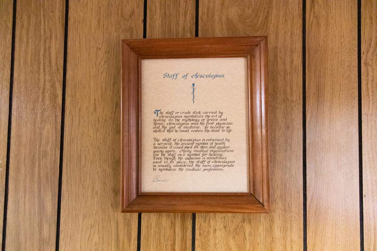 A framed description of Aesculapius’s staff, a symbol of the medical profession, hangs in Neal’s office.