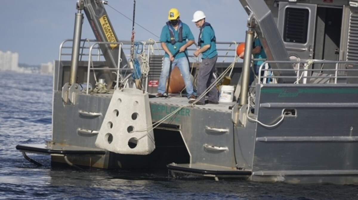 Scientists lower artificial reefs into the ocean. The reefs may be able to solve the erosion crisis on South Carolina’s coast lines.