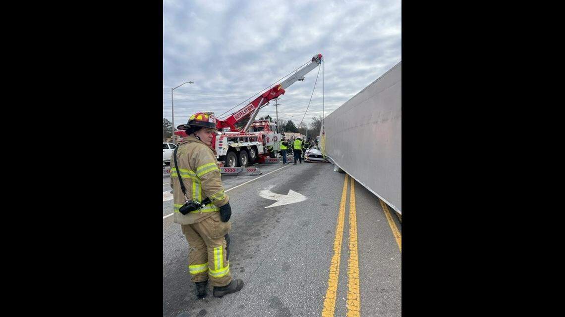 The truck was turning when it flipped onto the car, officials said.