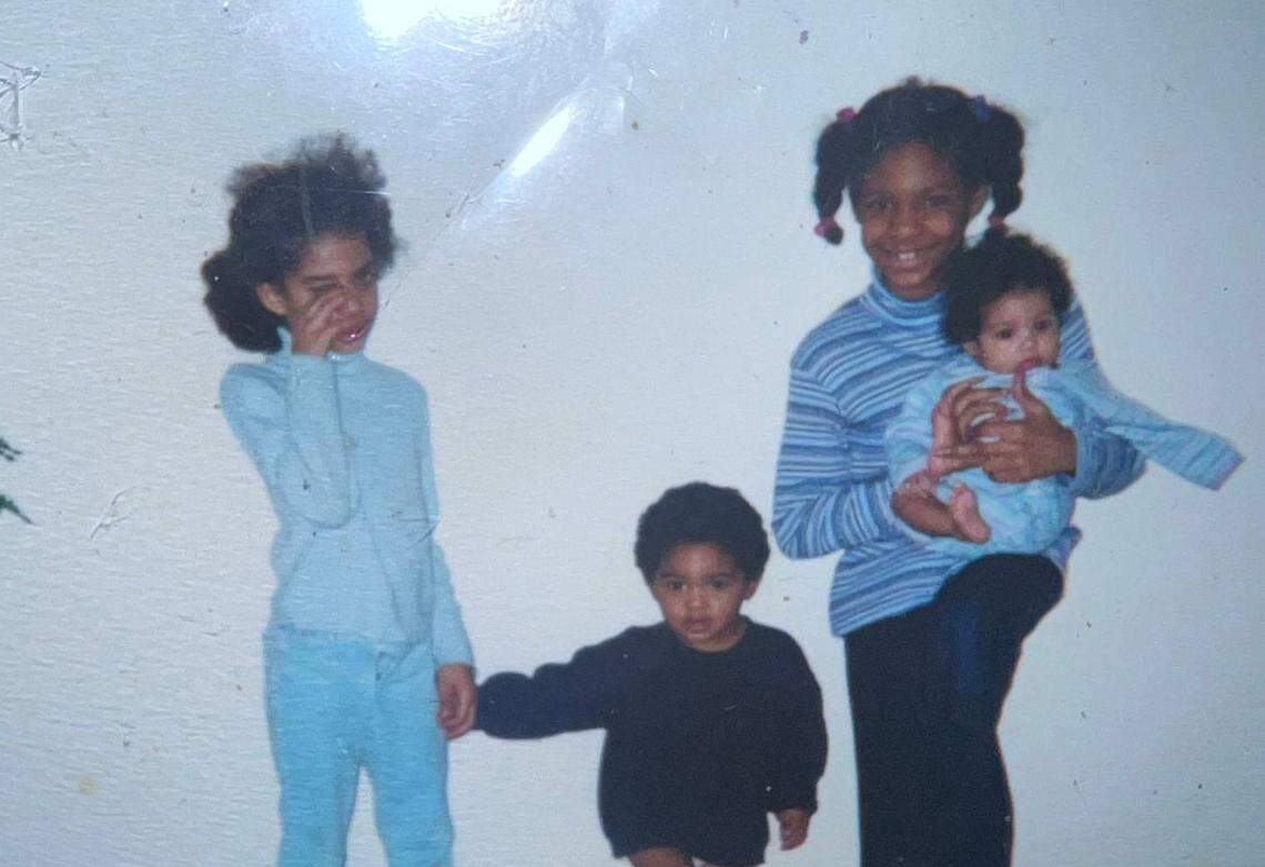 Kayla Berry (left) and Antwane Wells (middle), 1, hold hands in 2002. Verna Berry holds newborn Angel Wells.