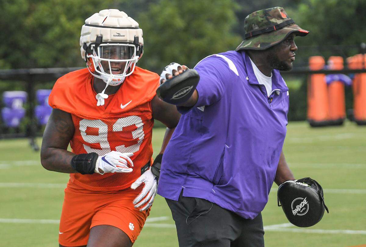 Clemson defensive tackle Caden Story (93) runs around defensive tackles Coordinator Nick Eason in a drill during practice at the Poe Indoor Facility in Clemson Monday, August 8, 2022.