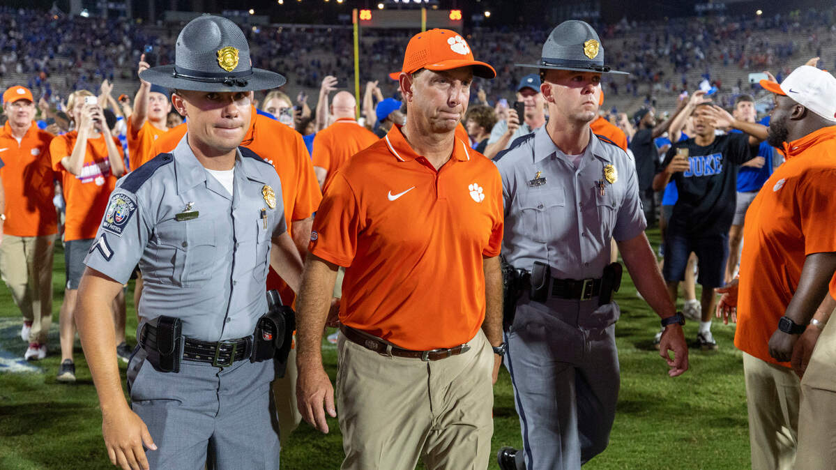 Clemson coach Dabo Swinney is escorted off the field as Duke fans celebrate their 28-7 victory over Clemson on Monday, September 4, 2023 at Wallace Wade Stadium Stadium in Durham, N.C.