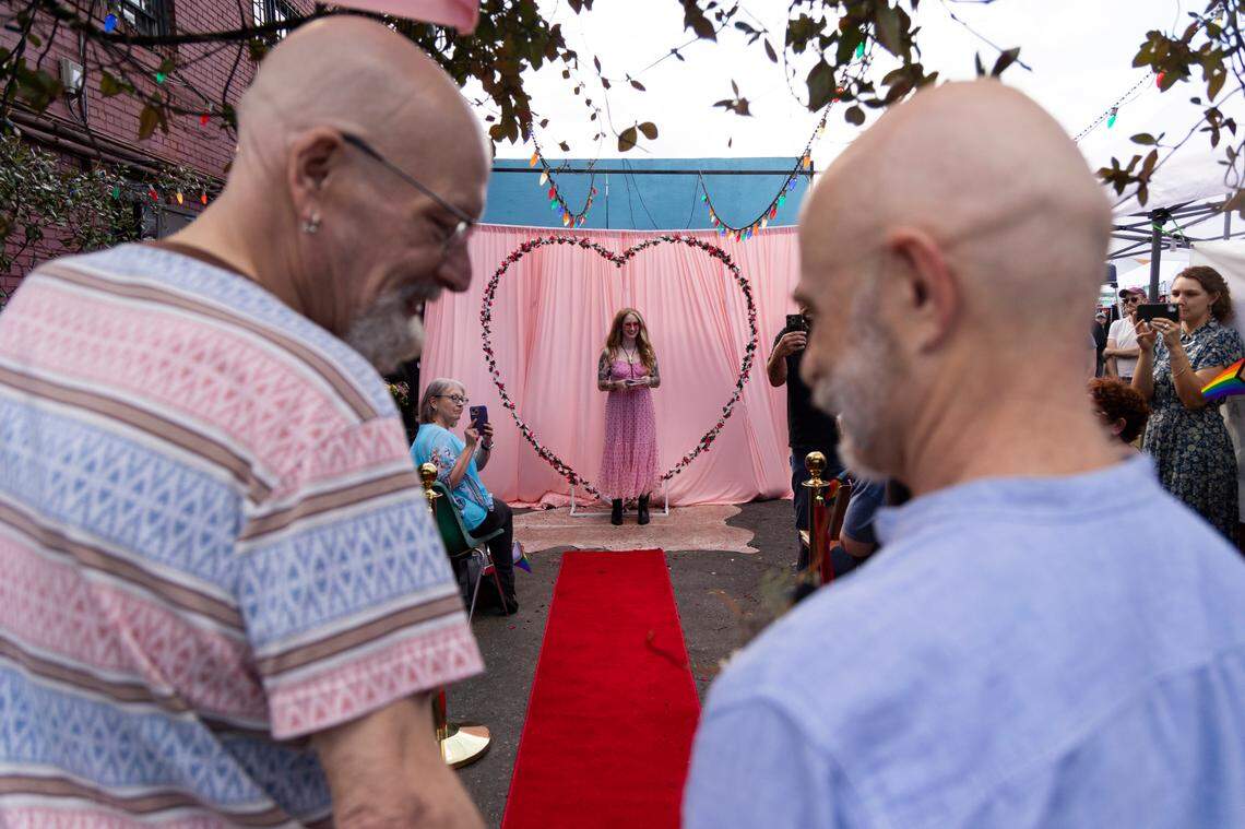 William Bonney and James Carpenter walk down the aisle for their wedding at Y’all-Mart, a quarterly art fair series, at Art Bar in Columbia, South Carolina on Sunday, February 9, 2025. The couple engaged in the fall of 2024, and Carpenter says they “impulsively” decided to marry at Y’all-Mart’s mass gay wedding. “Impulsively after six years,” Bonney added.