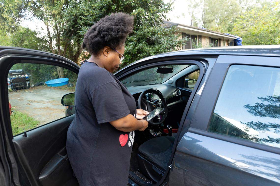 Cameo Miller charges her cell phone with her car charger on Thursday October. 3, 2024. Miller and many residents of the Denny Terrace neighborhood were still without power almost a week after Hurricane Helene blew through the area.