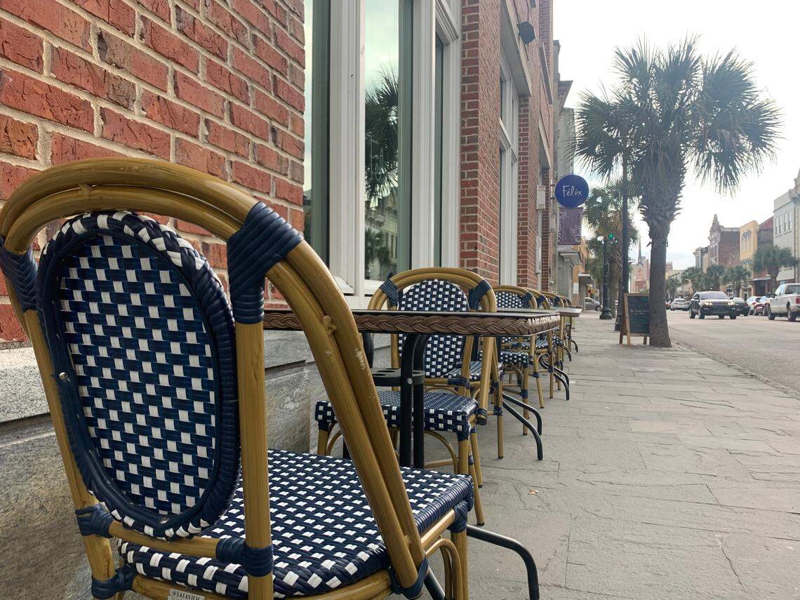 Navy-and-white rattan bistro chairs await patrons outside of Félix, a Parisian-inspired cocktail bar with a small-plate menu in downtown Charleston. Born out of a need to help local restaurants weather the COVID-19 pandemic, the sidewalk dining option is catching on in downtown Charleston and now, there’s a push to keep such outdoor dining long after the pandemic is gone.