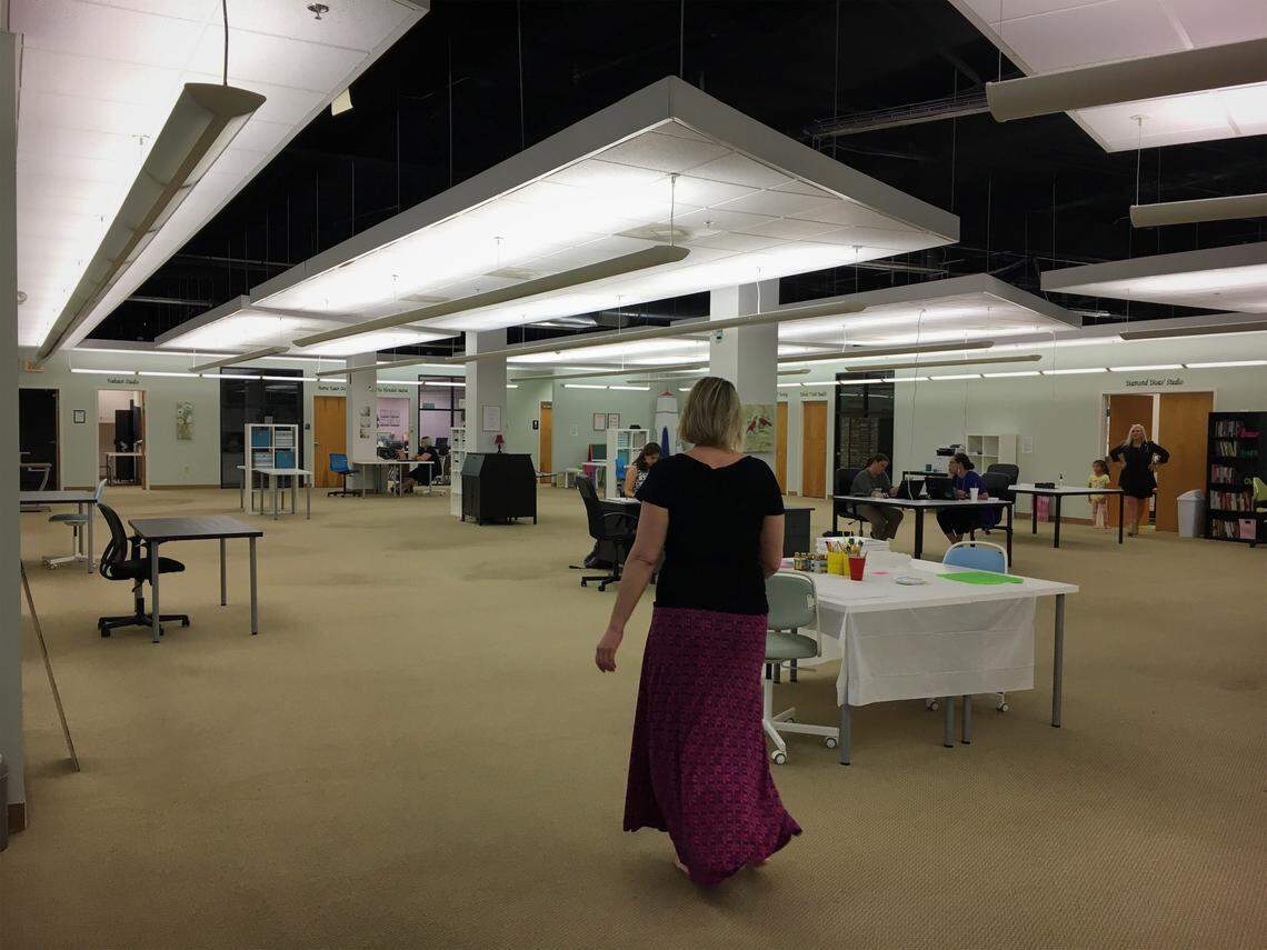CoCreate founder Kiri Rawson walks through a common working area of the 11,000 sq. ft. space. The coworking office has a podcasting studio, a content creation room, a play area for children, a classroom, private suites and swings hanging from the ceiling.