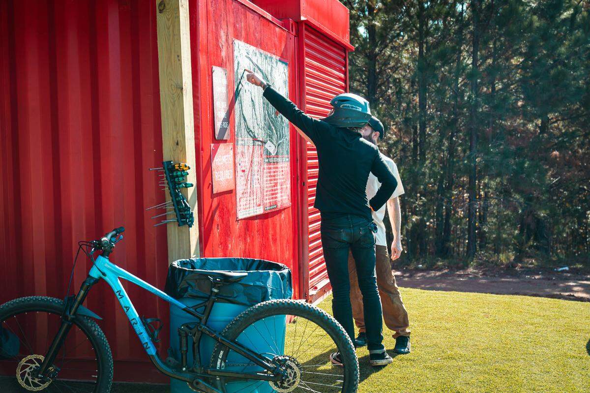 Riders check out the trail map at Fairfield County’s Rattlesnake Bike Park on opening day. Nov. 16, 2024.
