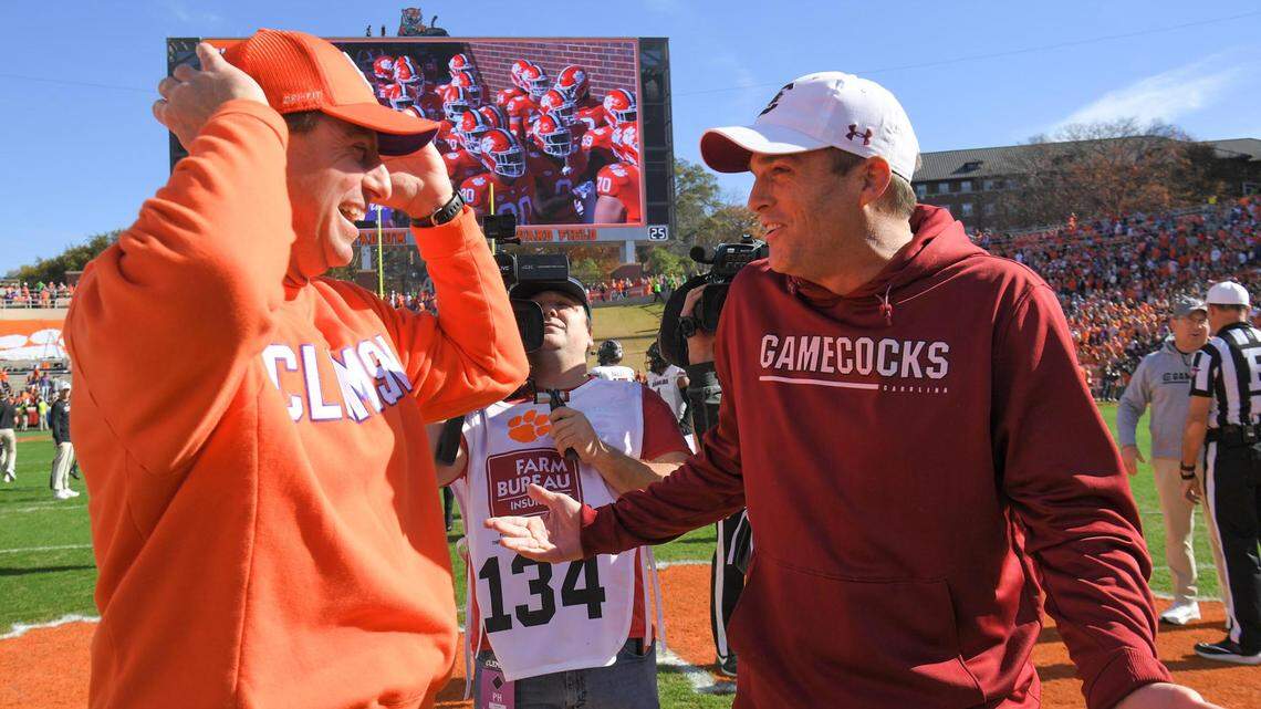 Clemson head coach Dabo Swinney, left, and South Carolina head coach Shane Beamer talk before the 2022 game at Memorial Stadium in Clemson, S.C. Saturday, Nov. 26, 2022.