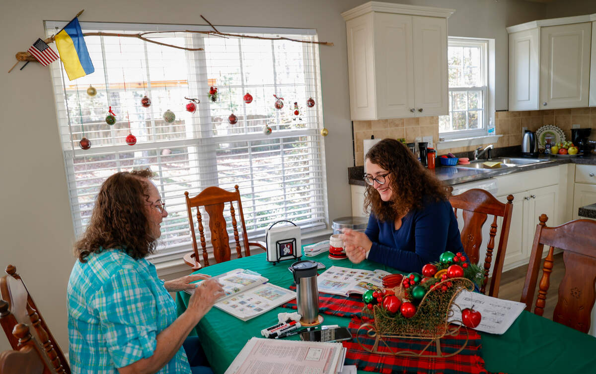 Patricia Webster, left, helps Olga Mazur with her English. Mazur, who fled Ukraine in mid August takes classes three days a week in her home.