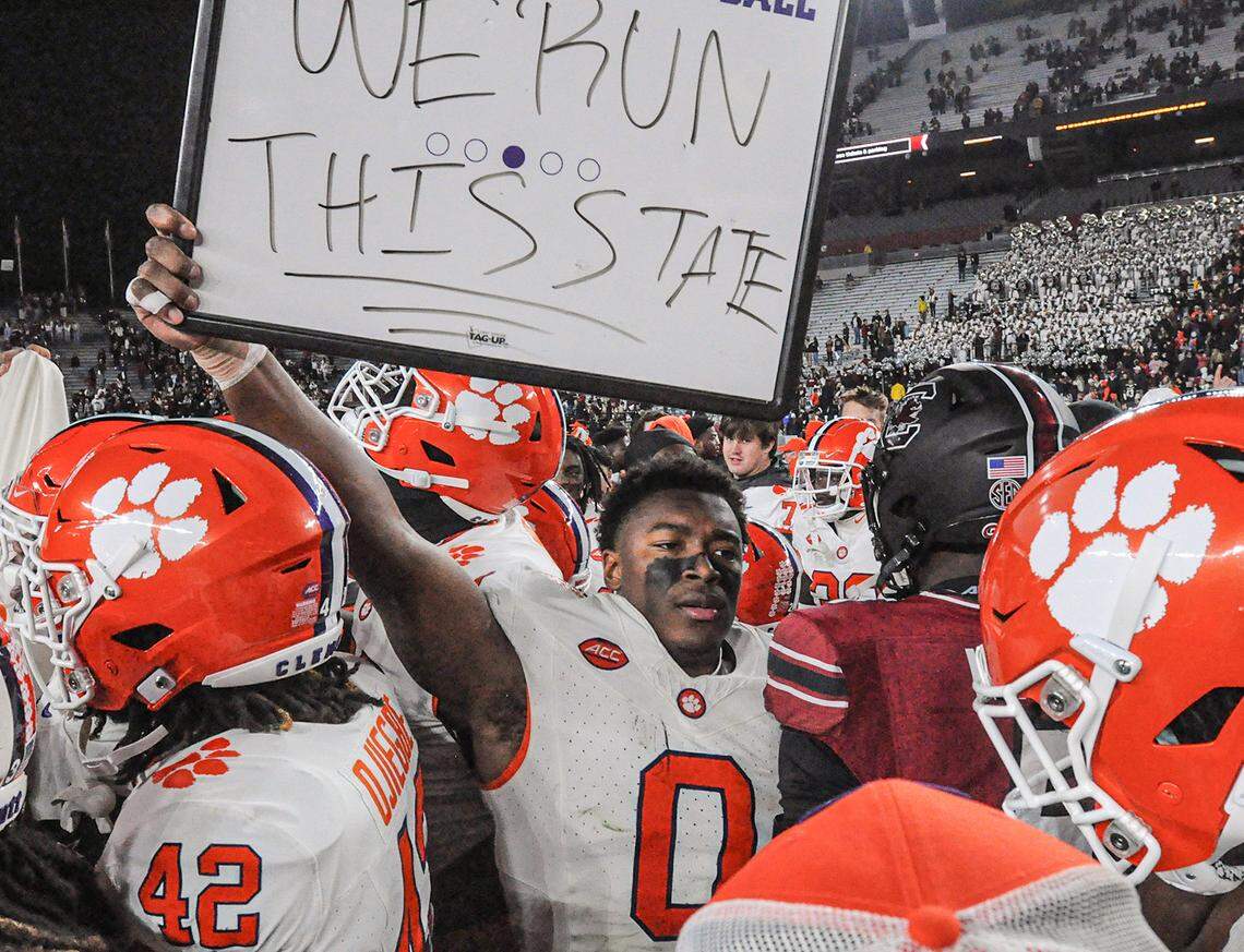 Nov 25, 2023; Columbia, South Carolina, USA; Clemson Tigers linebacker Barrett Carter (0) holds a sign “We Run This State” near South Carolina Gamecocks linebacker Grayson Howard (5) after defeating South Carolina at Williams-Brice Stadium. Clemson won 16-7. Mandatory Credit: Ken Ruinard-USA TODAY Sports