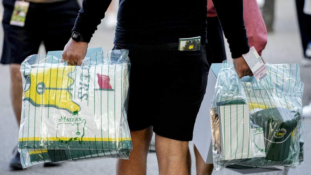 Patrons walk to their cars with purchases from the golf shop during a practice round for the Masters Tournament golf tournament at Augusta National Golf Club.