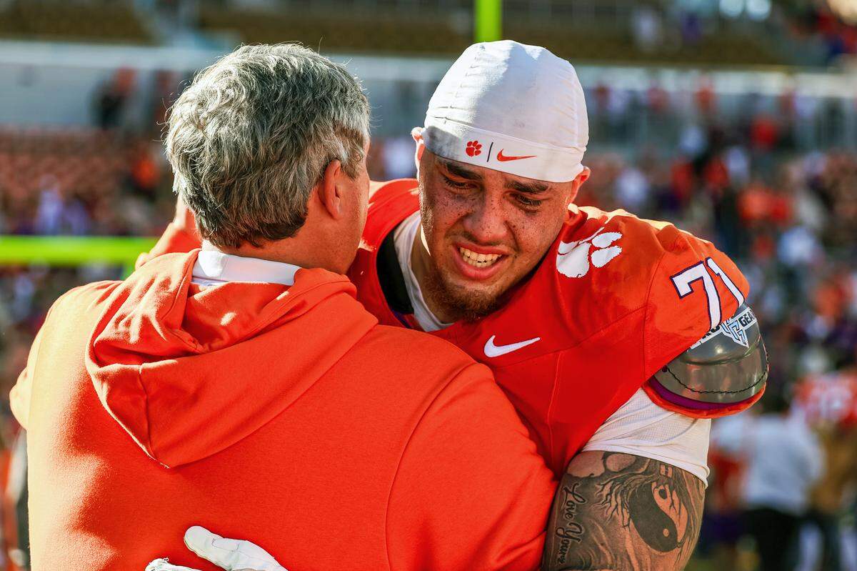 CLEMSON, SOUTH CAROLINA - NOVEMBER 01: Tristan Leigh #71 of the Clemson Tigers is consoled by offensive line coach Matt Luek after a football game against the Duke Blue Devils at Memorial Stadium on November 01, 2025 in Clemson, South Carolina.