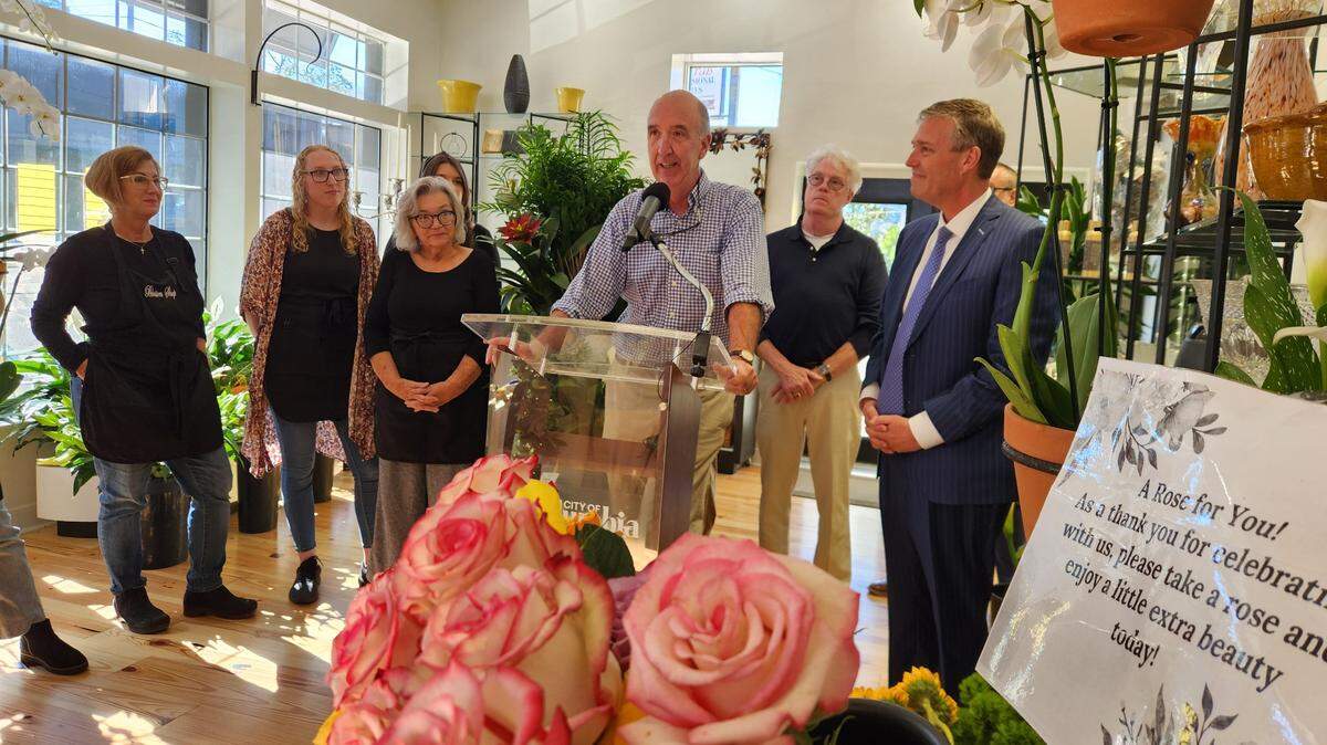 Blossom Shop co-owner Cubby Culbertson, center, speaks Nov. 12, 2024 at the grand opening of the floral shop’s new location at 1815 Gervais St. as Mayor Daniel Rickenmann, right, looks on.