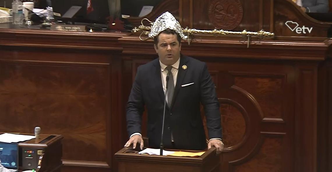 State Rep. Micah Caskey, R-Lexington, wears a tin foil hat on the House floor while speaking about a proposal to allow gold and silver to be used as legal tender in South Carolina on Wednesday, May 8, 2024. The proposal was made by state Rep. Jordan Pace, R-Berkeley, a House Freedom Caucus member.