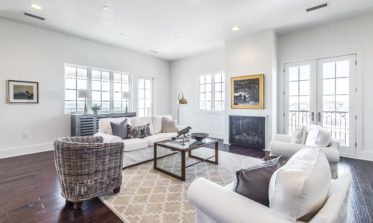 This Greenville condo includes an open concept kitchen, living area with gas fireplace, and dining area with French doors to outdoor balconies.