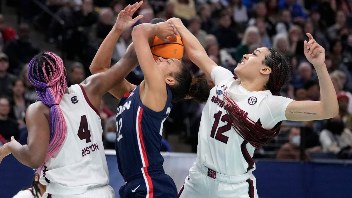 South Carolina’s Aliyah Boston and Brea Beal stop UConn’s Evina Westbrook during the second half of a college basketball game in the final round of the Women’s Final Four NCAA tournament Sunday, April 3, 2022, in Minneapolis.