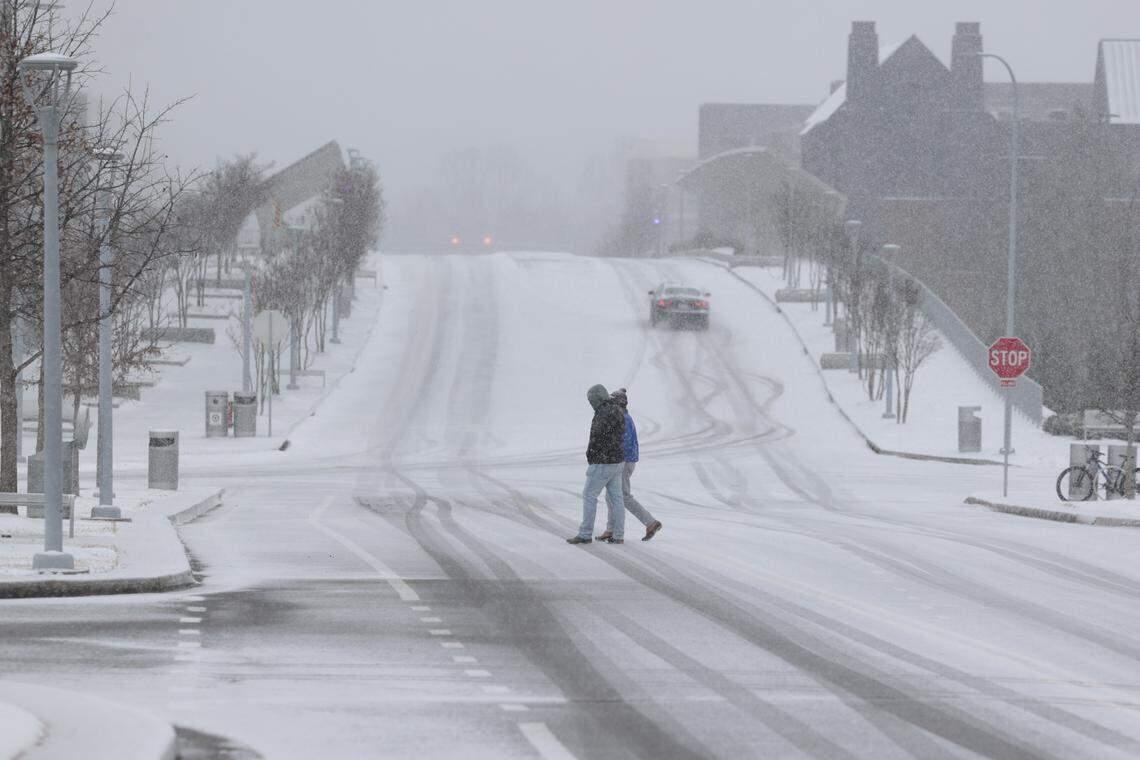 People cross Green Street as snow falls in Columbia on Saturday, Jan. 31, 2026. Snow is expected to fall all day in the Midlands.