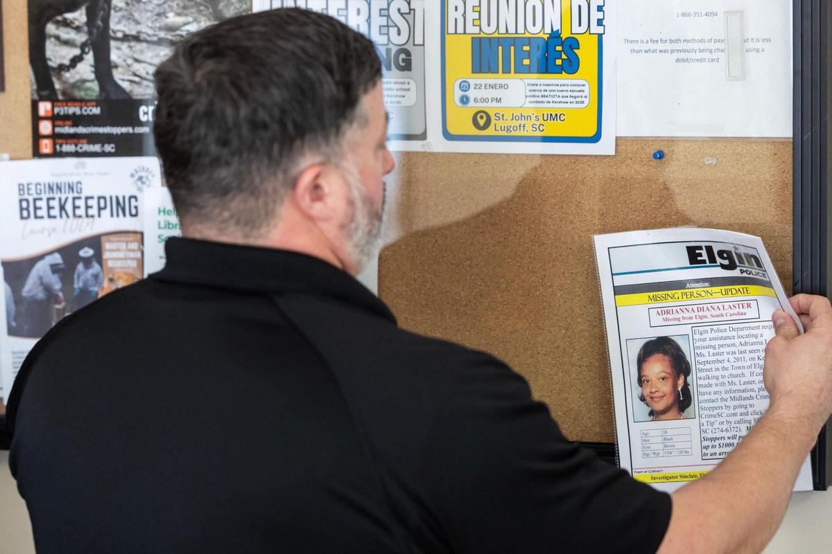Aaron Thrett removes a missing person’s poster for Adriana Laster in Elgin, South Carolina on Friday, January 19, 2024.