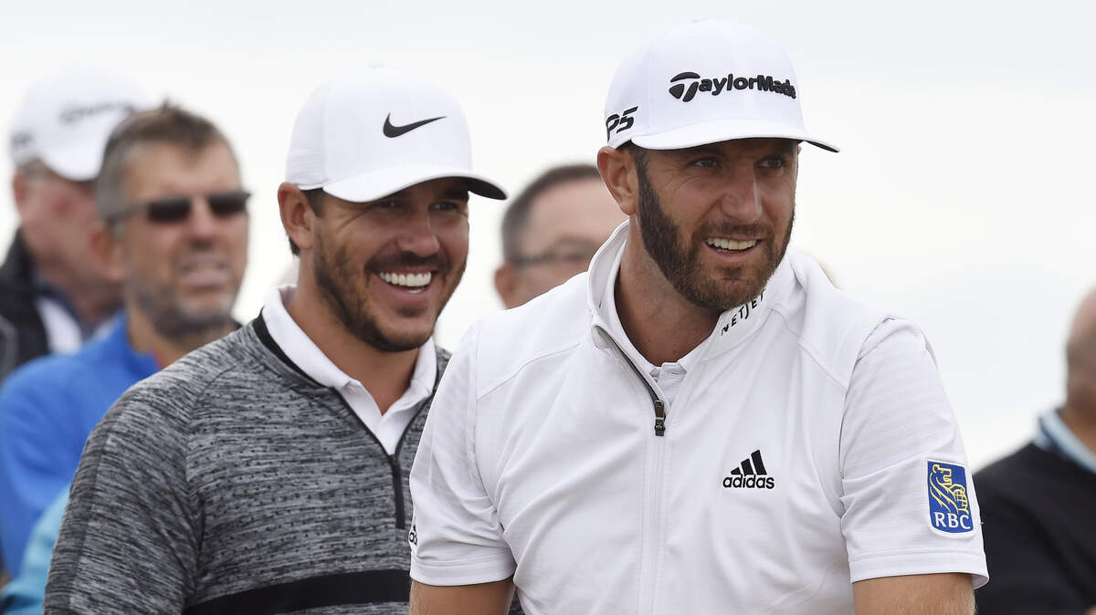Dustin Johnson watches his tee shot at the 15th hole with Brooks Koepka (behind) during a practice round this week of The Open Championship golf tournament at Carnoustie Golf Links.