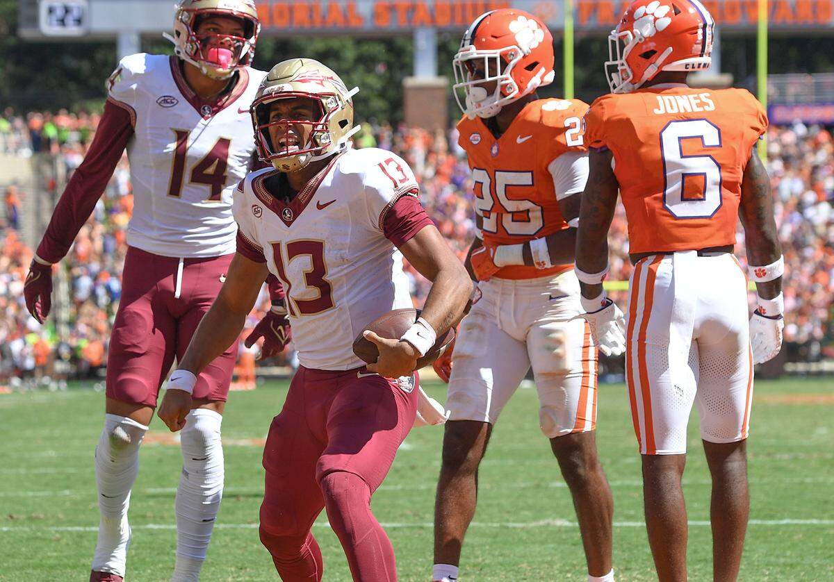 Florida State Seminoles quarterback Jordan Travis (13) reacts after scoring against Clemson Tigers safety Jalyn Phillips (25) during the second quarter at Memorial Stadium.