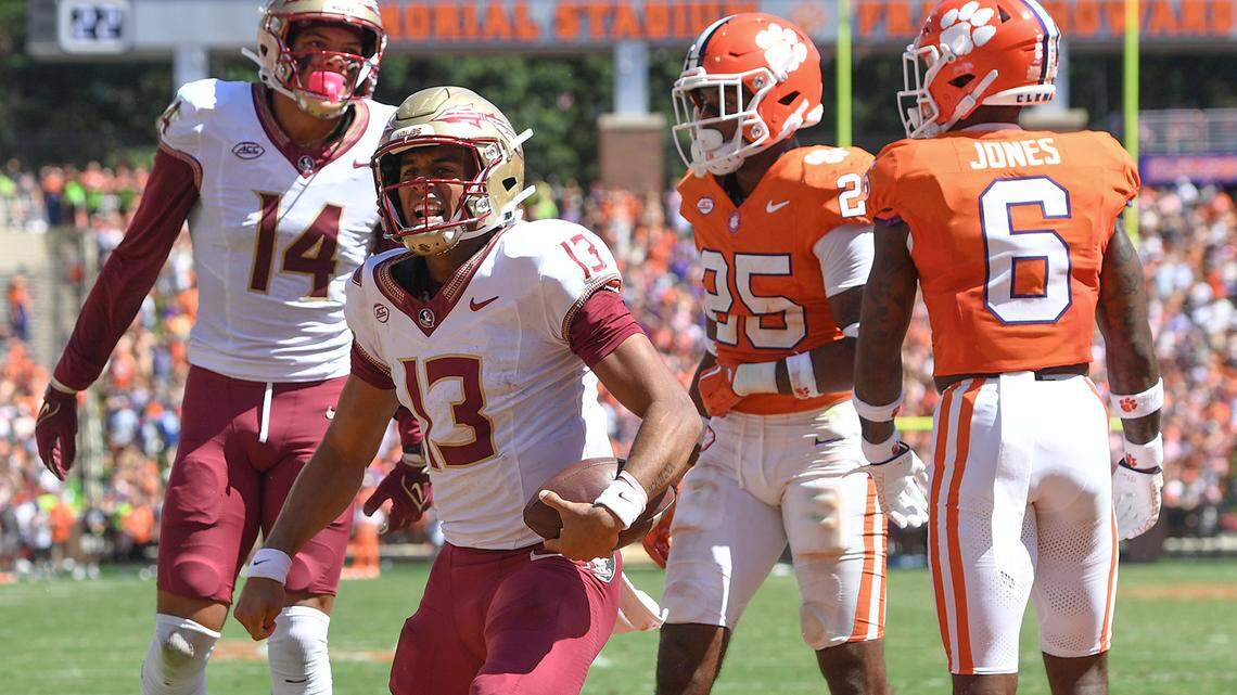 Florida State Seminoles quarterback Jordan Travis (13) reacts after scoring against Clemson Tigers safety Jalyn Phillips (25) during the second quarter at Memorial Stadium.