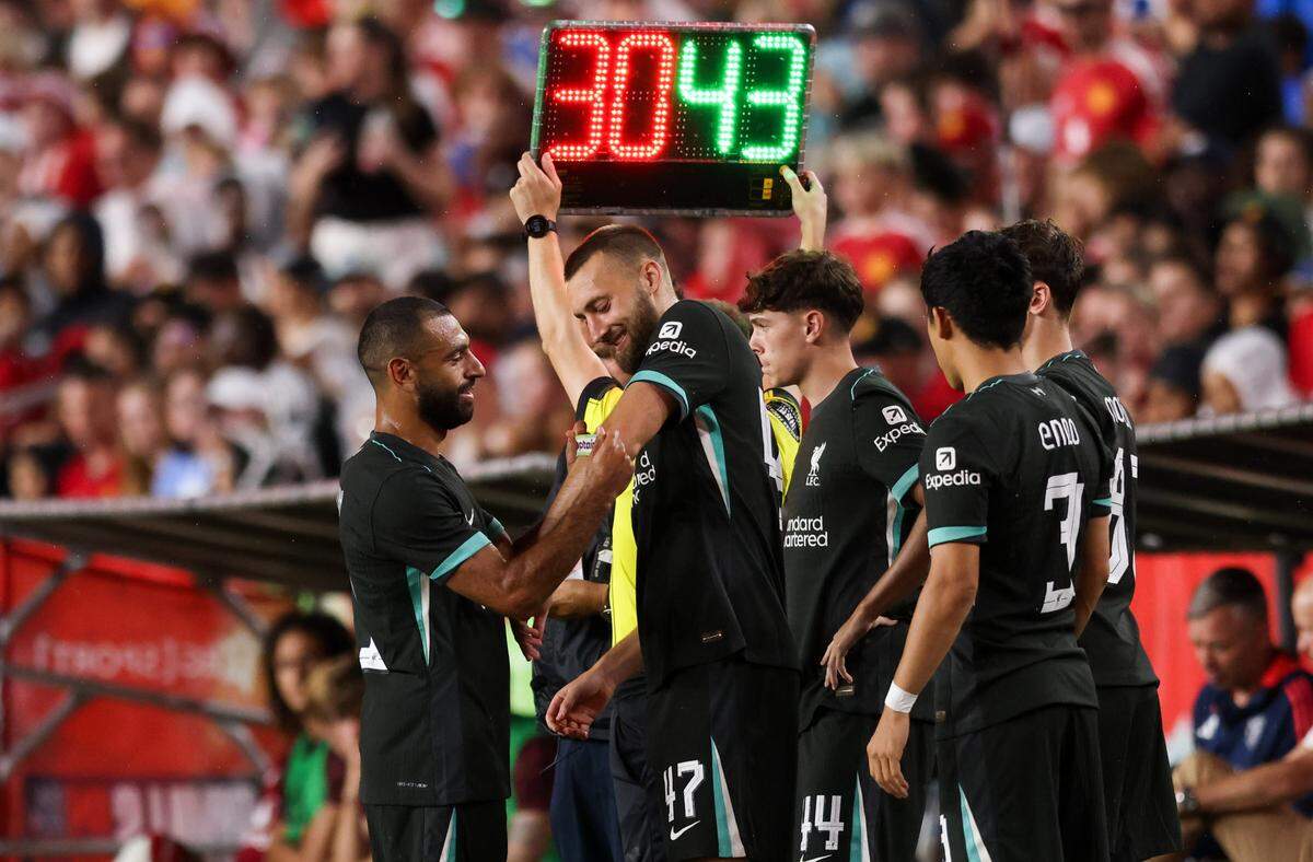 Liverpool forward Mohamed Salah (11) puts an armband on teammate Nathaniel Phillips (47) during the Rivals in Red International Friendly soccer match between Manchester United and Liverpool in Columbia on Saturday, August 3, 2024.