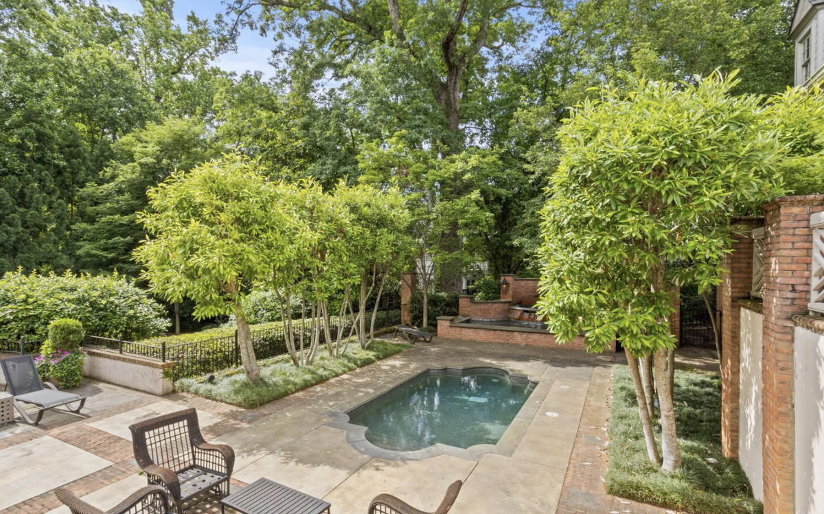The back yard has a lawn, pool, hot tub, and water feature.