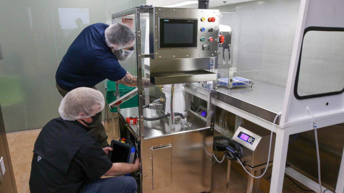 Travis Bailey and John Diamond assemble a robot at Nephron Pharmaceuticals. Diamond and other University of South Carolina Mechanical Engineering students designed the robot to fill syringes with medicine.