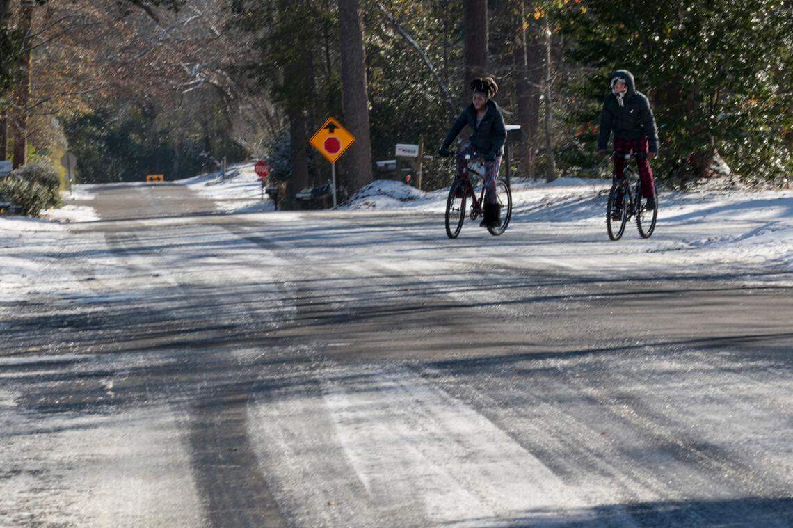 Bicyclists pedal down snow covered Live Oak Street in the South Kilbourne neighborhood. on Wednesday, Jan. 22, 2025.