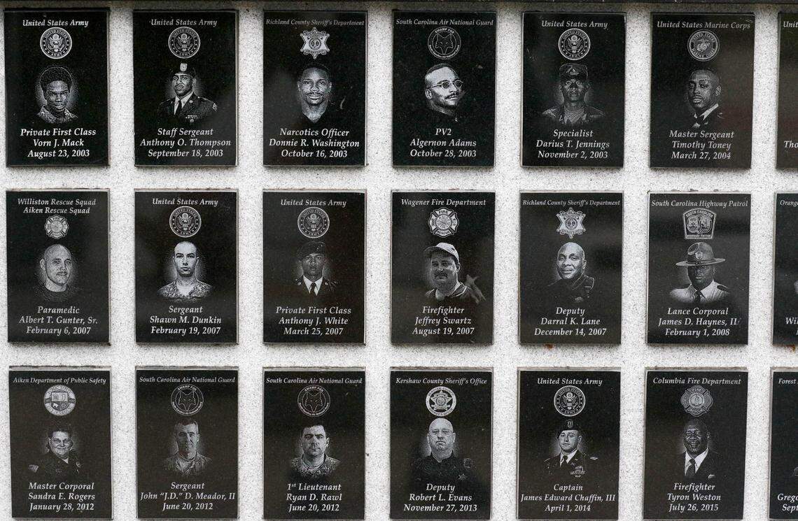 A remembrance wall, with images of local first responders who lost their lives, sits behind the 9/11 memorial in Columbia.