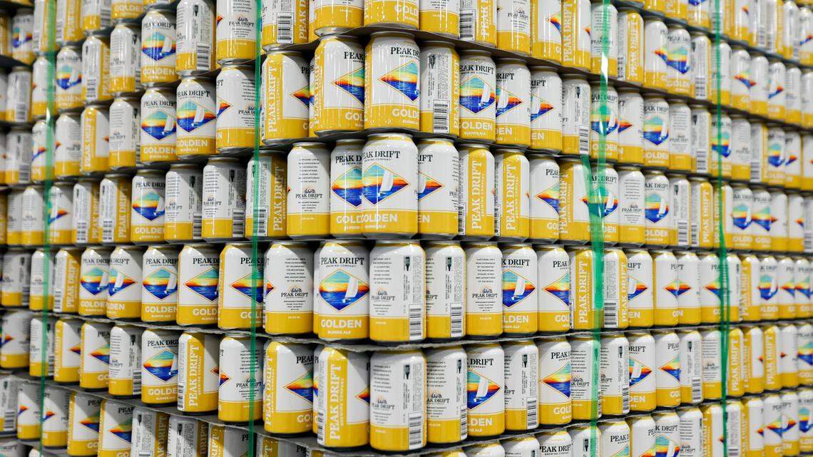 Cans of Peak Drift Golden blond ale are stacked during the ribbon cutting celebration at the Peak Drift Brewing production facility in Columbia on Wednesday, Jan. 18, 2023.