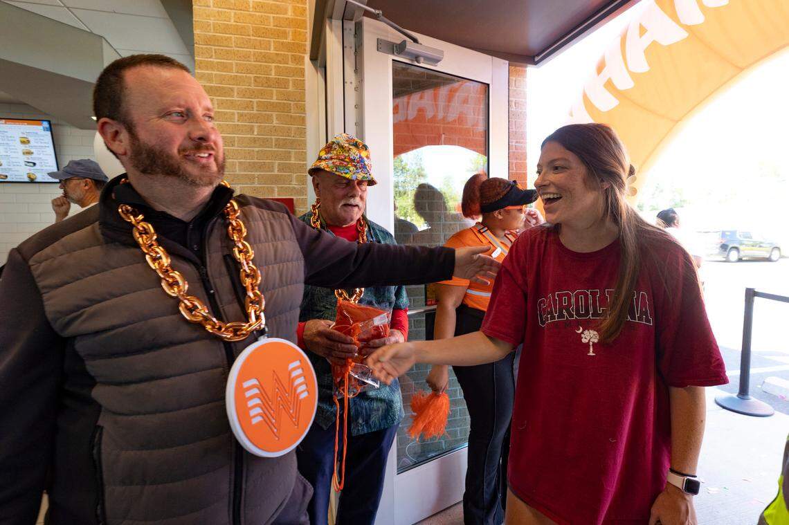 Connor Smoak, embraces Katy Bone at the grand opening of Whataburger in Irmo on Monday, Sept. 9, 2024. Smoke, Phil Foust, center, and Bone were among the first people in line at the restaurant.