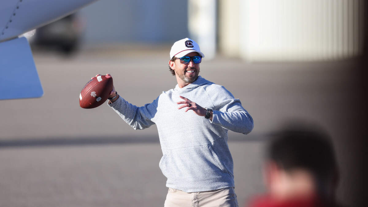 New South Carolina offensive coordinator Kendal Briles tosses a football around after arriving at Jim Hamilton-LB Owens Airport in Columbia on Thursday.