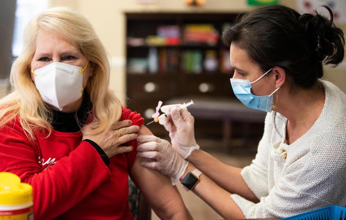 Sherry Barclay receives the first shot of the coronavirus vaccine from Dr. Jennifer Henzler at Wellmore of Lexington on Wednesday, December 30, 2020. Barclay is excited for the extra layer of protection for herself and her patients at Wellmore.