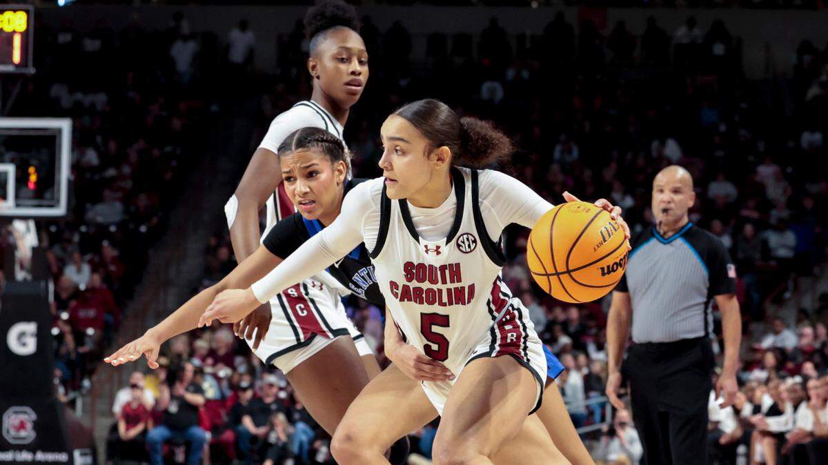 University of South Carolina’s Tessa Johnson (5) moves the ball as Kentucky’s Lexi Blue (4) pressures during the first half of action in the Colonial Life Arena on Sunday, March 2, 2025.